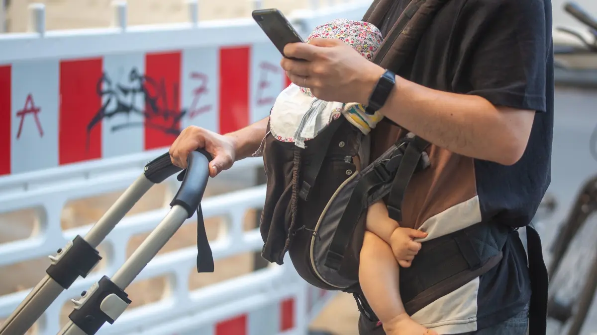 Vater mit Baby in der Trage: SYMBOLBILD - 09.09.2023, Berlin: Sorgenfrei dank Elterngeld? In Sachsen warten Eltern im Schnitt fast zwei Monate, bis ihr Antrag bearbeitet ist. (zu dpa: «Eltern in Sachsen warten fast zwei Monate auf Elterngeld») Foto: Fernando Gutierrez-Juarez/dpa +++ dpa-Bildfunk +++