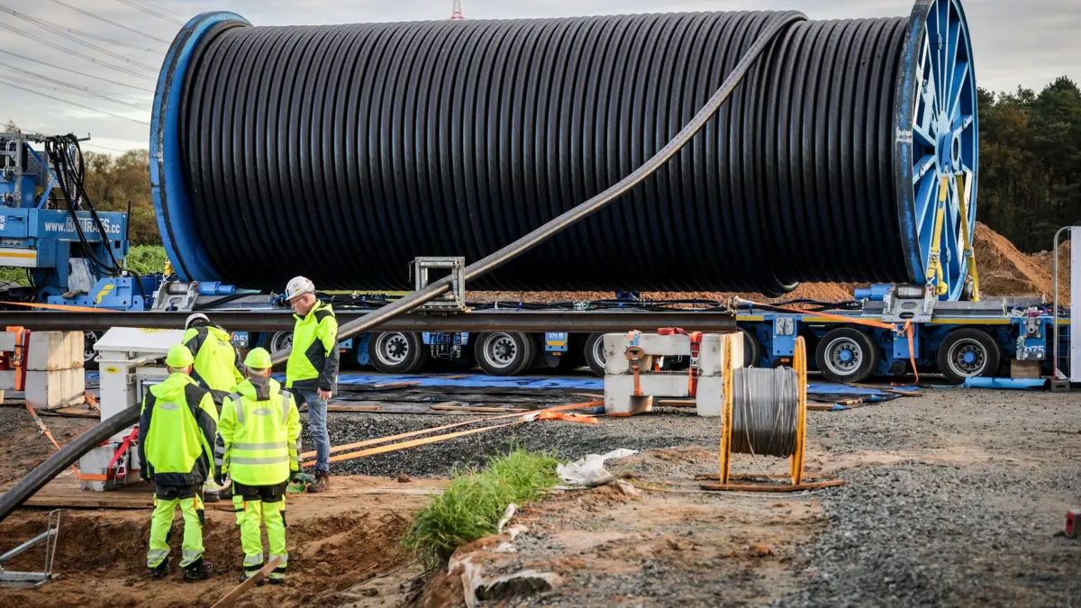 Erster Kabeleinzug bei Suedlink: ARCHIV - 22.10.2024, Niedersachsen, Heeslingen: Ein Stromkabel wird auf einer Baustelle der Erdkabelverbindung des Stromtrassenbetreibers TenneT während des Suedlink-Erdkabelpressetages von einer Trommel in ein Kabelschutzrohr verlegt. (Archiv) (zu dpa: «Baustart auf nächstem Abschnitt der Stromtasse Suedlink») Foto: Focke Strangmann/dpa +++ dpa-Bildfunk +++