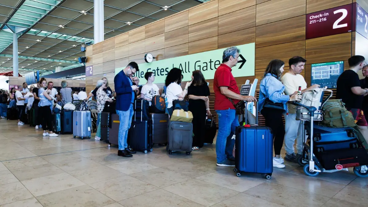 Cyberangriff auf Flughäfen in Europa - Berlin: 20.09.2025, Brandenburg, Schönefeld: Passagiere warten in einem Terminal am Berliner Flughafen BER. Eine Firma für Check-in und Boarding an Flughäfen ist Opfer eines Cyberangriffs geworden. Das sorgt für Wartezeiten und Verspätungen an mehreren Flughäfen in Europa. (zu dpa: «Flughafen-Probleme: Marathon-Rückreise wird Herausforderung») Foto: Carsten Koall/dpa +++ dpa-Bildfunk +++