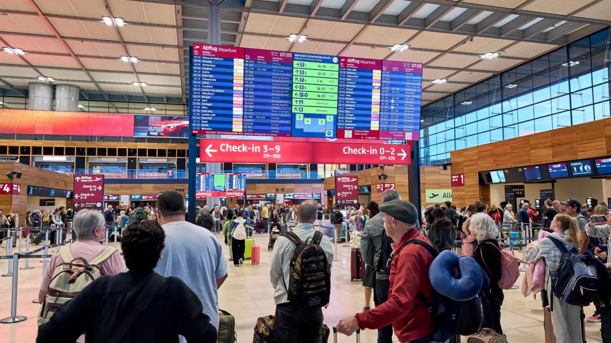 Nach dem Cyberangriff an europäischen Airports - Berlin: 22.09.2025, Brandenburg, Schönefeld: Zahlreiche Fluggäste informieren sich an den Abflugtafeln im Terminal 1 des Flughafens Berlin Brandenburg. Nach einem breit angelegten Cyberangriff auf europäische Flughäfen bekommen Passagiere die Auswirkungen auch am Montag noch zu spüren. Vor allem am BER rechnet man nach dem Berlin-Marathon mit einem großen Andrang. Foto: Michael Ukas/dpa +++ dpa-Bildfunk +++