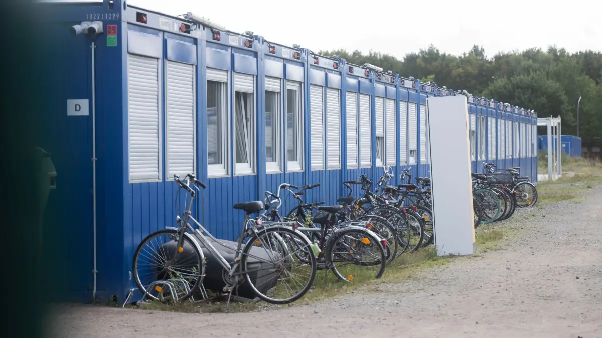 Container-Unterkunft Upahl: 22.09.2024, Mecklenburg-Vorpommern, Upahl: Fahrräder und ein Möbelstück stehen vor Wohncontainern in der Flüchtlingsunterkunft. Aus der umstrittenen Unterkunft sind die ersten Geflüchteten ausgezogen. Der Landkreis hat zwei neue Asylbewerber-Unterkünfte in Gadebusch und Selmsdorf errichtet. Die Unterkunft in Upahl soll bald Geschichte sein. Foto: Philip Dulian/dpa +++ dpa-Bildfunk +++