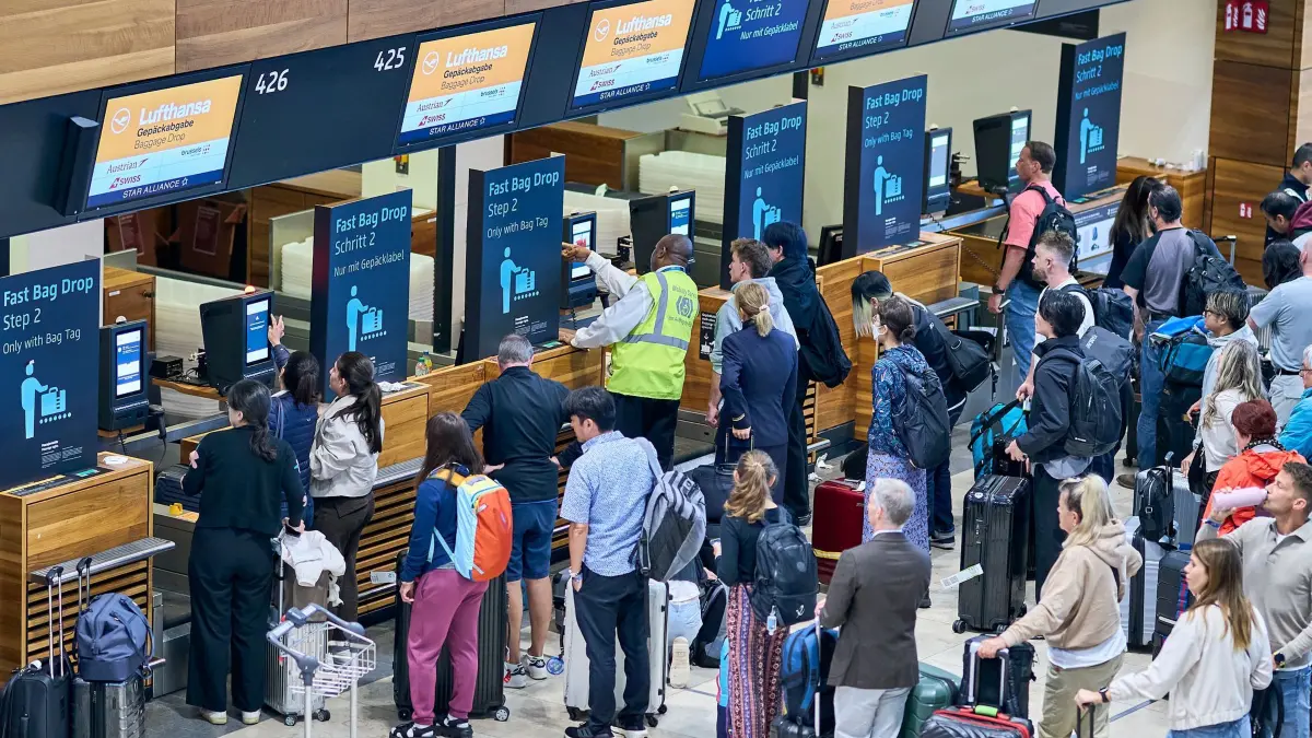 Nach dem Cyberangriff an europäischen Airports - Berlin: 22.09.2025, Brandenburg, Schönefeld: Zahlreiche Fluggäste warten vor den Check-in-Schaltern im Terminal 1 des Flughafens Berlin Brandenburg. Nach einem breit angelegten Cyberangriff auf europäische Flughäfen bekommen Passagiere die Auswirkungen auch am Montag noch zu spüren. Vor allem am BER rechnet man nach dem Berlin-Marathon mit einem großen Andrang. (zu dpa: «Lange Schlangen am Flughafen nach Cyberangriff und Marathon») Foto: Michael Ukas/dpa +++ dpa-Bildfunk +++