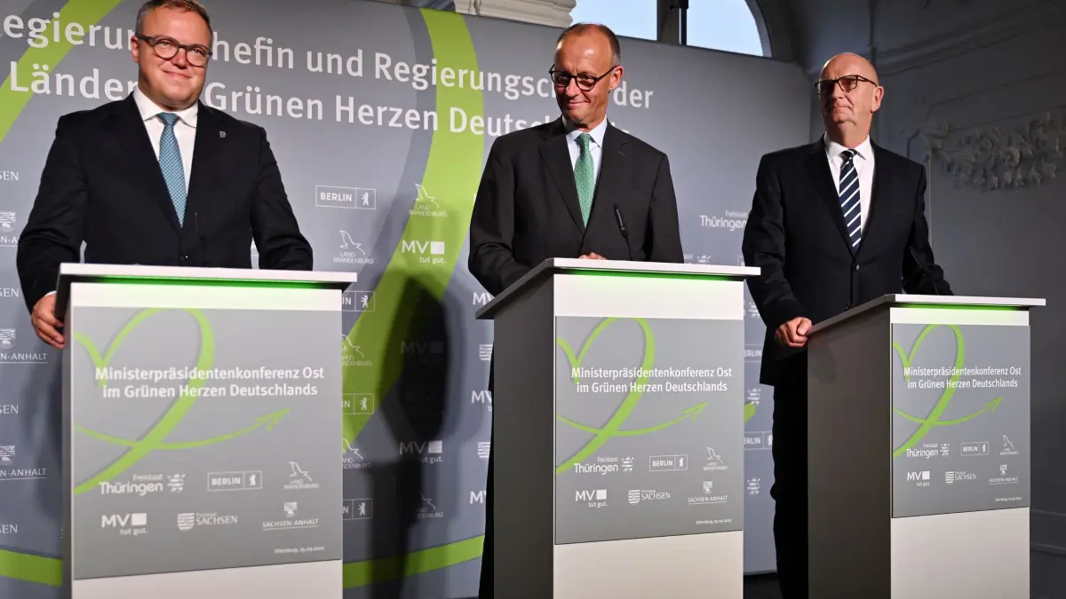 Konferenz der ostdeutschen Regierungschefs: 25.09.2025, Thüringen, Ettersburg: Mario Voigt (CDU, l-r), Ministerpräsident von Thüringen, Bundeskanzler Friedrich Merz (CDU) und Dietmar Woidke (SPD), Ministerpräsident von Brandenburg, nehmen an einer Pressekonferenz im Schloss Ettersburg teil. Die Ministerpräsidenten und Ministerpräsidentin der ostdeutschen Länder treffen sich auf Schloss Ettersburg bei Weimar. Auf der Agenda der Ministerpräsidentenkonferenz Ost stehen Themen wie die Verteidigungsstruktur in Ostdeutschland, Wirtschaftspolitik und der Kampf gegen Hass im Netz. Foto: Martin Schutt/dpa +++ dpa-Bildfunk +++