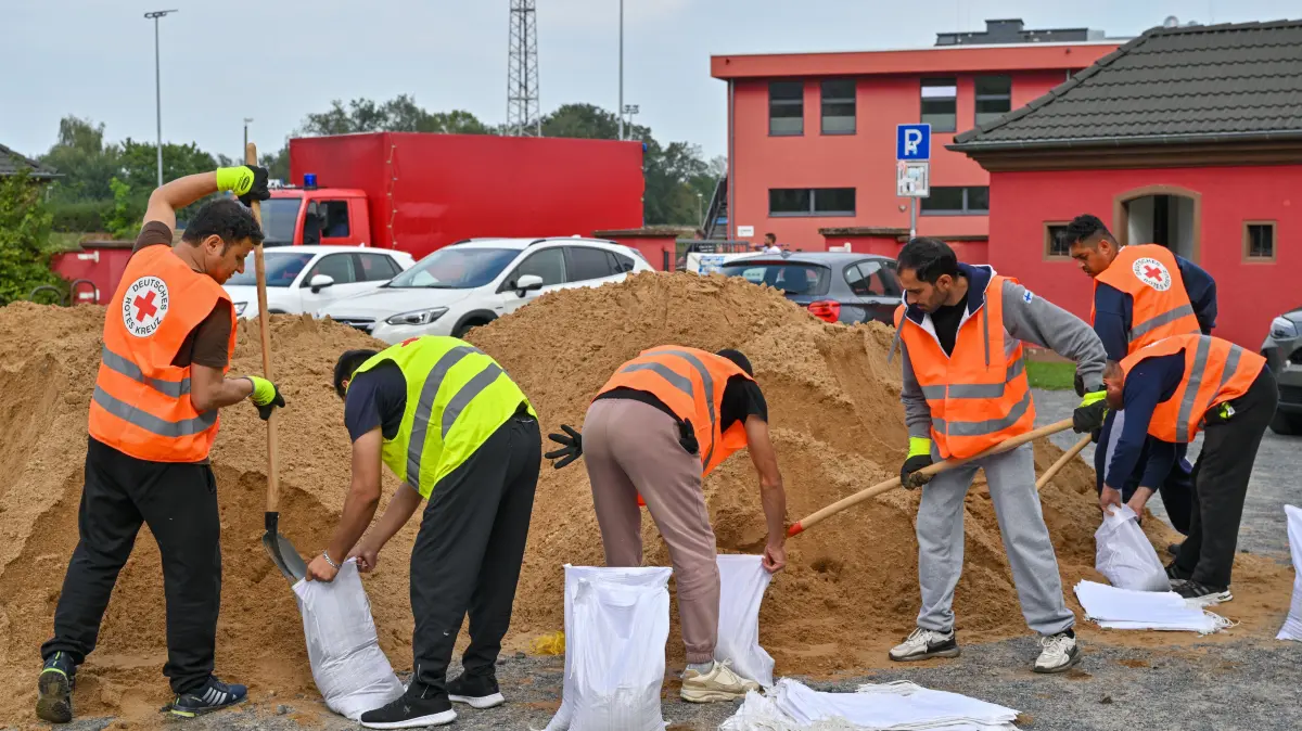 Migranten aus einer Unterkunft der Zentralen Ausländerbehörde des Landes Brandenburg (ZABH) in Frankfurt (Oder) helfen bei einem freiwilligen Einsatz beim Befüllen von Sandsäcken gegen das drohende Hochwasser am deutsch-polnischen Grenzflusses Oder. Noch ist unsicher, wie ernst die Hochwasserlage in Brandenburg wirklich wird. Angesichts weiter steigender Wasserstände kommen aber Krisenstäbe in Kommunen zusammen. Angesichts weiter steigender Flusspegel kommen in Kommunen entlang der Oder die Hochwasser-Krisenstäbe zusammen. Für heute wollten etwa Frankfurt (Oder) und der Landkreis Oder-Spree mit Feuerwehr und Technischem Hilfswerk über die Lage in den kommenden Tagen beraten. +++ dpa-Bildfunk +++