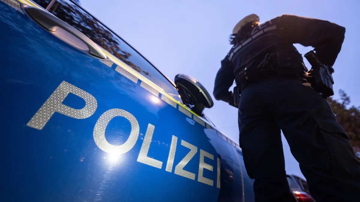 ILLUSTRATION - 30.11.2023, Baden-Württemberg, Stuttgart: Eine Polizistin steht neben einem Polizeifahrzeug. (zu dpa: «Mehr Körperverletzungen, mehr Raub, mehr Sexualstraftaten») Foto: Marijan Murat/dpa +++ dpa-Bildfunk +++