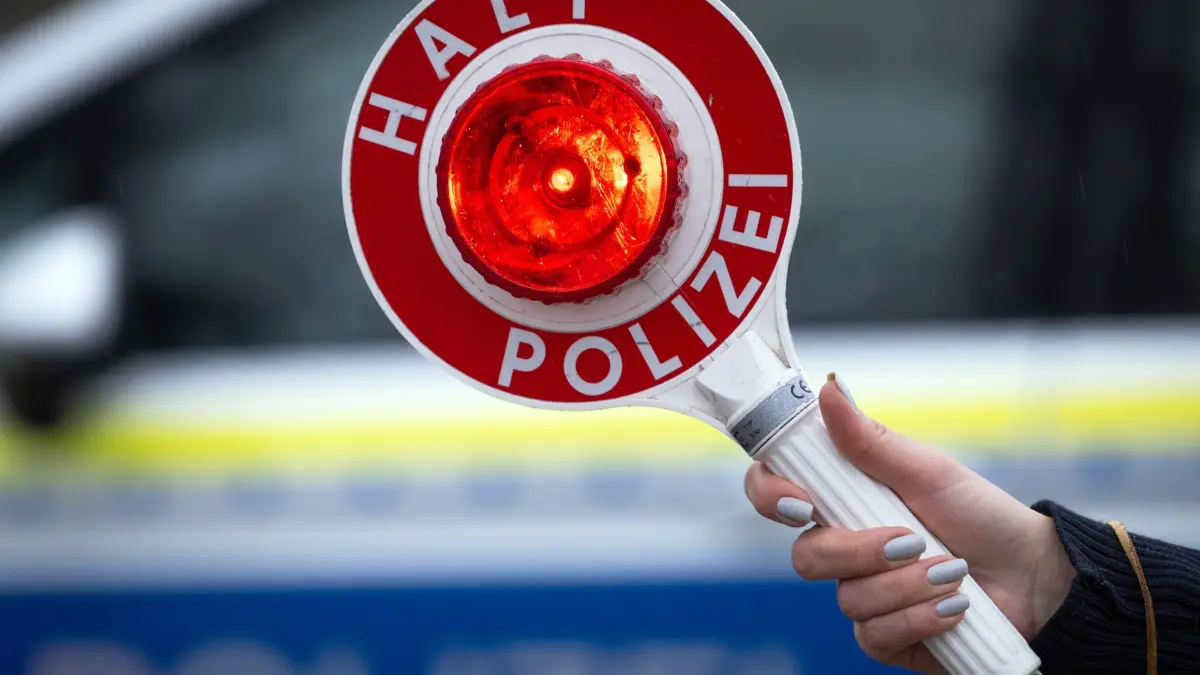 Verkehrskontrolle: ARCHIV - 22.03.2024, Brandenburg, Trebbin: Eine Polizistin hält während einer Verkehrskontrolle eine Polizeikelle mit der Aufschrift „Halt Polizei“. (zu dpa: «Ermittlungen wegen Verdachts auf illegales Autorennen») Foto: Soeren Stache/dpa +++ dpa-Bildfunk +++