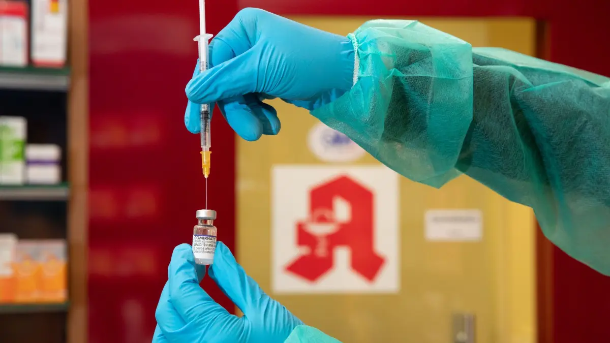 Lange Nacht des Impfens: ILLUSTRATION - 08.02.2022, Niedersachsen, Bad Essen: Eine Apothekerin zieht während einer gestellten Situation in ihrer Apotheke den Impfstoff Comirnaty vom Hersteller Biontech / Pfizer gegen das Coronavirus mit einer Spritze auf. (zu dpa: «Grippe- und Corona-Impfungen bis spätabends») Foto: Friso Gentsch/dpa +++ dpa-Bildfunk +++