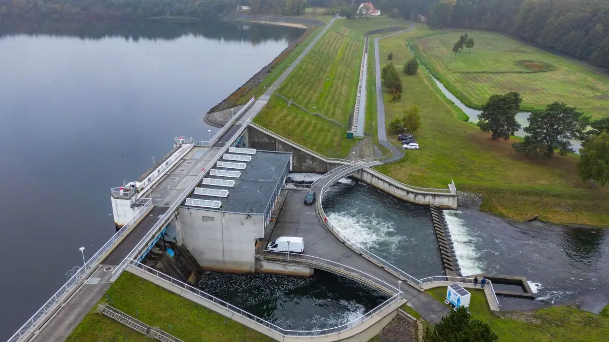 60 Jahre Talsperre Spremberg: 08.10.2025, Brandenburg, Neuhausen/Spree: Die Talsperre Spremberg mit dem Ablassbauwerk (Luftaufnahme mit einer Drohne). Mit einem Festakt und Technik-Touren wurde am selben Tag das 60-jährige Bestehen der Talsperre Spremberg gefeiert. Die größte wasserwirtschaftliche Anlage des Landes wurde 1965 in Betrieb genommen und spielt laut brandenburgischem Umweltministerium bis heute eine zentrale Rolle für den Wasserhaushalt der Lausitz und der Spree. Foto: Patrick Pleul/dpa +++ dpa-Bildfunk +++
