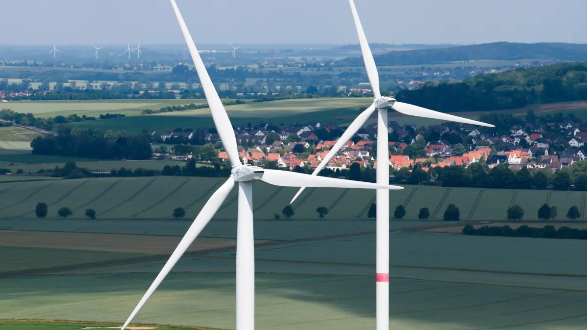 ARCHIV - 11.06.2025, Niedersachsen, Springe: Zwei Windräder stehen in der Nähe der Ortschaft Bennigsen in der Region Hannover (Luftaufnahme mit einer Drohne). (zu dpa: «Streit um Klimatopf: Geld für Zertifikate statt Klimaschutz?») Foto: Julian Stratenschulte/dpa +++ dpa-Bildfunk +++