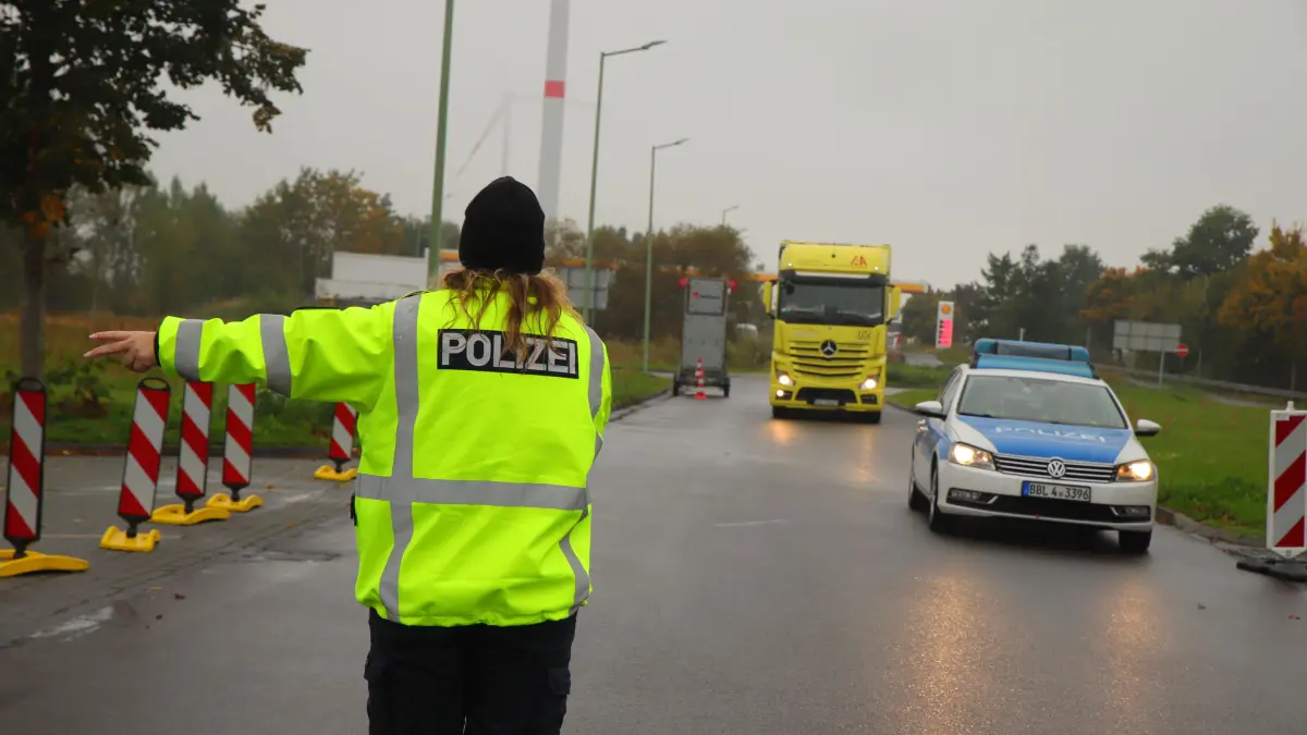 Kontrolle auf der A12 zwischen Fürstenwalde und Frankfurt (Oder): Eine Polizeibeamtin weist einem Lkw-Fahrer den Weg zum Kontrollplatz.