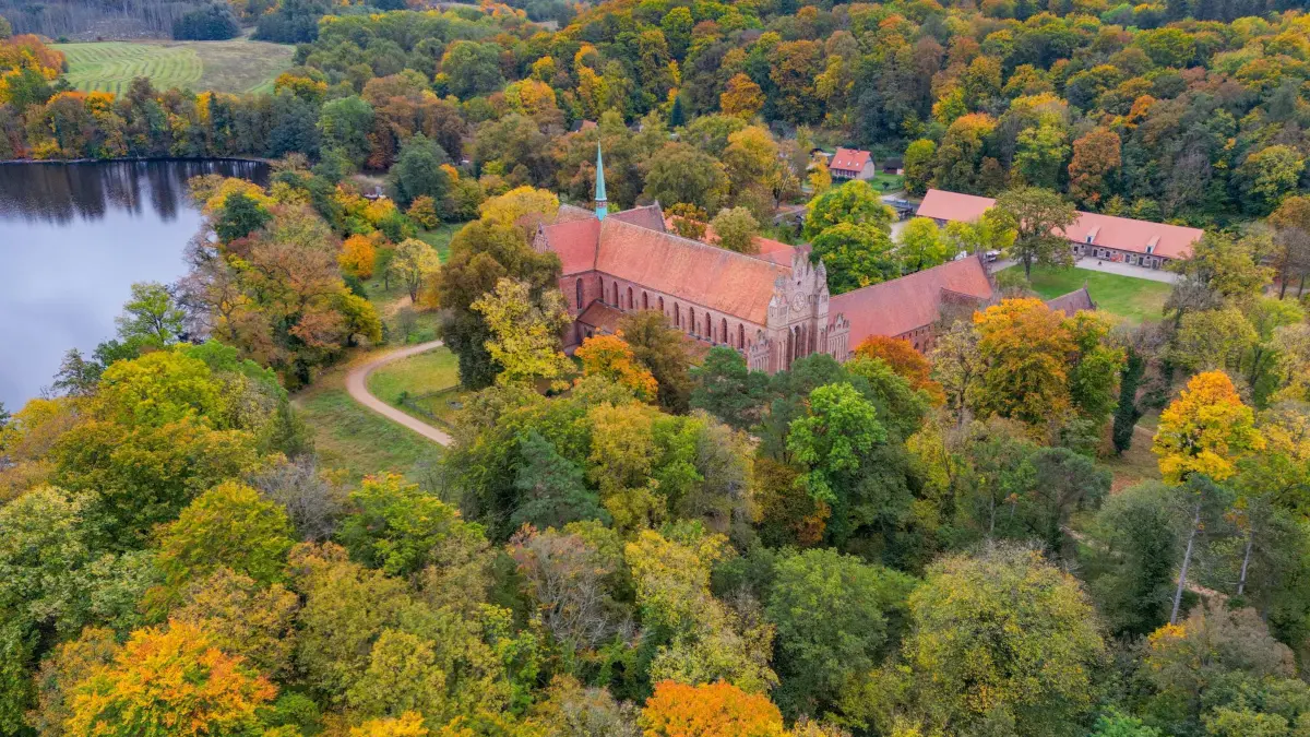 Herbst am Kloster Chorin: 16.10.2025, Brandenburg, Chorin: Herbstlich bunt sind die Laubbäume am Kloster Chorin gefärbt (Luftaufnahme mit einer Drohne). Die Geschichte des Klosters Chorin reicht lange in die Vergangenheit zurück. Das heutige Denkmal mit großer Ausstrahlung über die Region hinaus ist Mönchen zu verdanken, die sich vor 750 Jahren hier niederließen. 1272 wurden erstmals das Zisterzienser in Chorin erwähnt. Die Choriner Klosterkirche wurde zum Vorbild für Kirchen in Berlin, Angermünde und Neubrandenburg. Foto: Patrick Pleul/dpa +++ dpa-Bildfunk +++