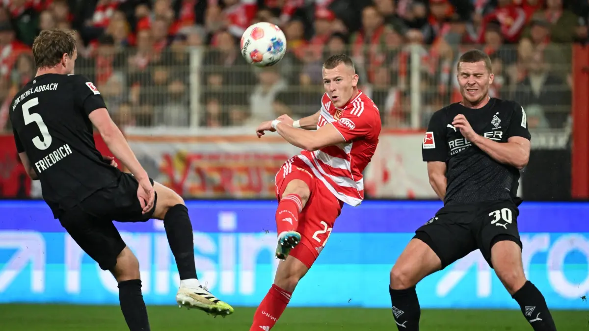 1. FC Union Berlin - Borussia Mönchengladbach: 17.10.2025, Berlin: Fußball: Bundesliga, 1. FC Union Berlin - Borussia Mönchengladbach, 7. Spieltag, An der Alten Försterei, Tim Skarke (M, 1. FC Union Berlin) in Aktion gegen Nico Elvedi (r, Borussia Mönchengladbach) und Marvin Friedrich (Borussia Mönchengladbach). Foto: Soeren Stache/dpa - WICHTIGER HINWEIS: Gemäß den Vorgaben der DFL Deutsche Fußball Liga bzw. des DFB Deutscher Fußball-Bund ist es untersagt, in dem Stadion und/oder vom Spiel angefertigte Fotoaufnahmen in Form von Sequenzbildern und/oder videoähnlichen Fotostrecken zu verwerten bzw. verwerten zu lassen. +++ dpa-Bildfunk +++