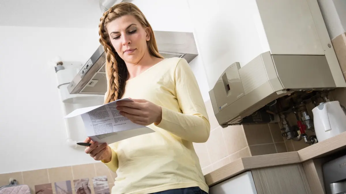 Frau liest Brief zum Anbieterwechsel eines Energieversorgers: ILLUSTRATION - Immer eine gute Idee: Den eigenen Gastarif regelmäßig prüfen und vielleicht zu einem günstigeren Anbieter wechseln. (zu dpa: «Finanztip: Gaskosten so niedrig wie seit einem Jahr nicht») Foto: Christin Klose/dpa-tmn - Honorarfrei nur für Bezieher des dpa-Themendienstes +++ dpa-Themendienst +++