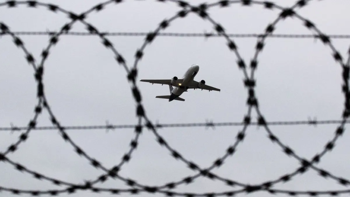 ARCHIV - 06.01.2020, Niedersachsen, Hannover: ILLUSTRATION - Ein Flugzeug startet - fotografiert durch Stacheldraht am Flughafenzaun. (zu dpa: «Abschiebeflug nach Bagdad - NRW mahnt Schutz für Jesiden an») Foto: Julian Stratenschulte/dpa +++ dpa-Bildfunk +++