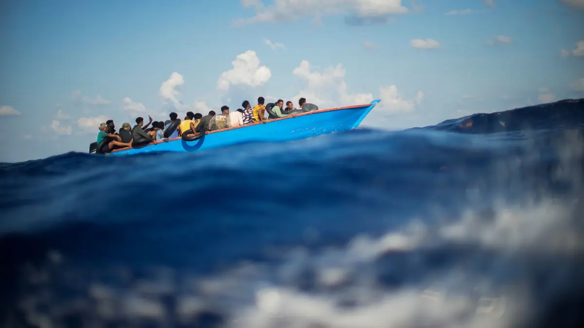 Seenotrettung im Mittelmeer: ARCHIV - 11.08.2022, Italien, ---: Migranten sitzen in einem Holzboot im Mittelmeer. (zu dpa: «UNHCR beklagt Todesopfer bei Bootsunglücken in der Ägäis») Foto: Francisco Seco/AP/dpa +++ dpa-Bildfunk +++