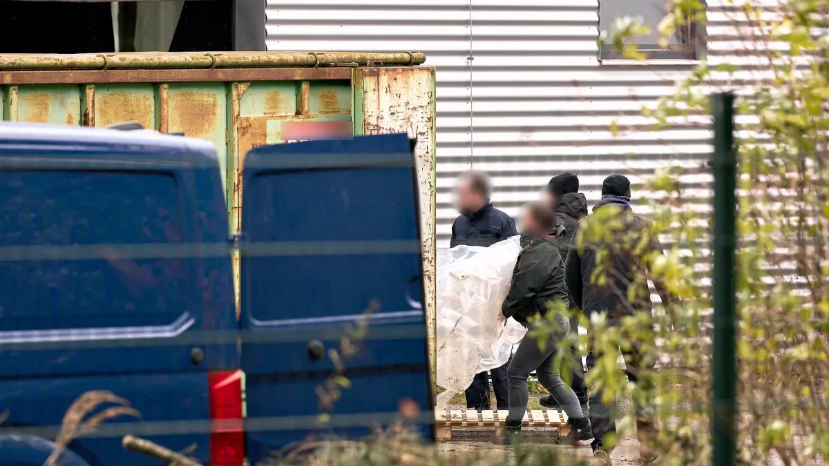 Razzia in Brandenburg: 30.10.2025, Brandenburg, Nauen: Zollbeamte tragen Utensilien aus einer Halle, in der ein riesiges illegales Drogenlabor ausgehoben wurde. Foto: Michael Ukas/dpa - ACHTUNG: Beamte und Hinweis auf Firma aus rechtlichen Gründen gepixelt +++ dpa-Bildfunk +++