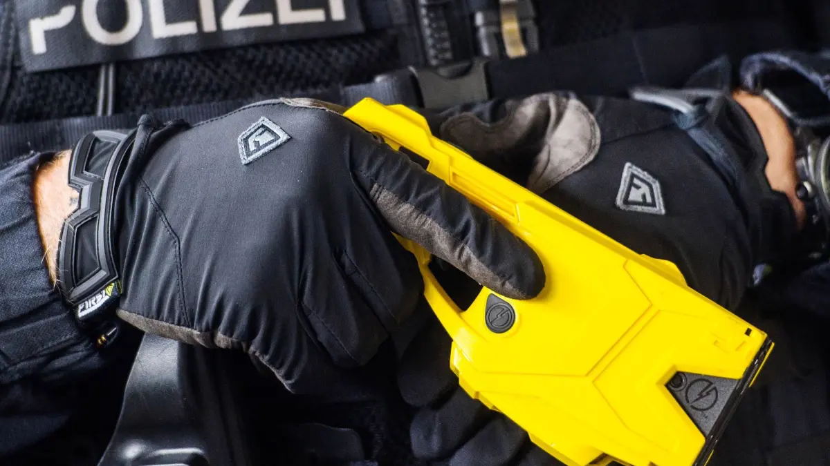 Taser: ARCHIV - 04.07.2018, Hessen, Wiesbaden: Ein Polizeibeamter hält einen sogenannten Taser. (zu dpa: «Zahl der Tasereinsätze in Hessen gestiegen») Foto: Andreas Arnold/dpa +++ dpa-Bildfunk +++