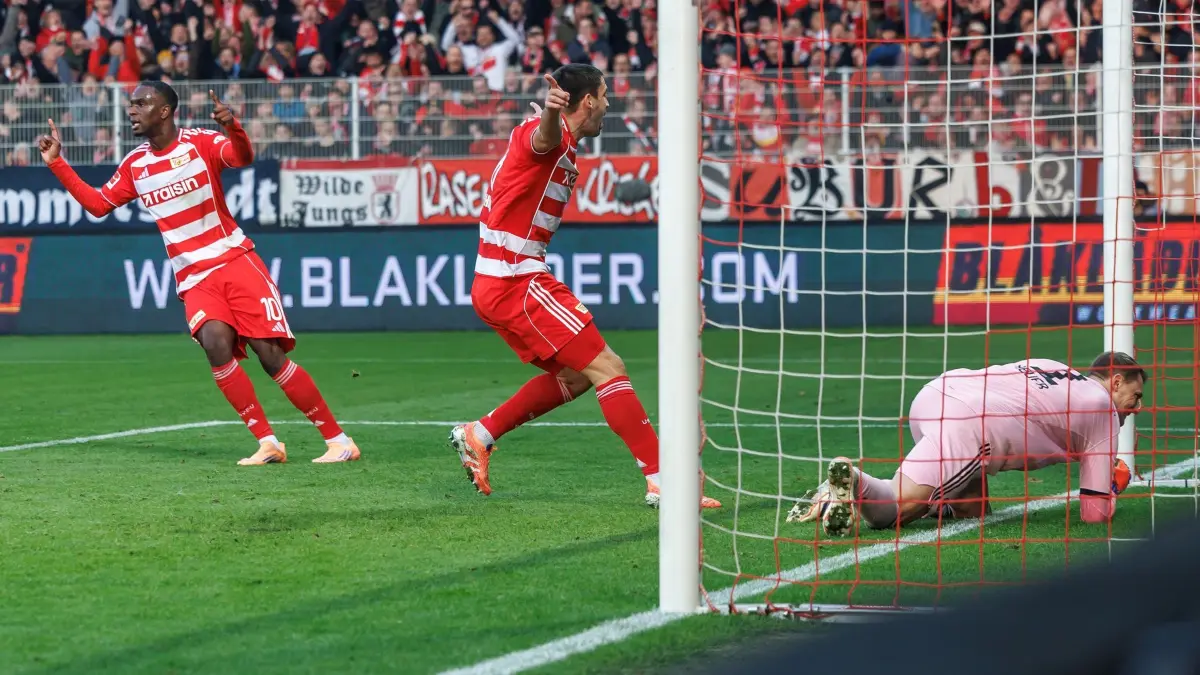 1. FC Union Berlin - Bayern München: 08.11.2025, Berlin: Fußball: Bundesliga, 1. FC Union Berlin - Bayern München, 10. Spieltag, An der Alten Försterei. Ilyas Ansah (l, Union Berlin) und Rani Khedira (M, Union Berlin) jubeln nach Unions Treffer zum 1:0 gegen Torwart Manuel Neuer (Bayern München). Foto: Andreas Gora/dpa - WICHTIGER HINWEIS: Gemäß den Vorgaben der DFL Deutsche Fußball Liga bzw. des DFB Deutscher Fußball-Bund ist es untersagt, in dem Stadion und/oder vom Spiel angefertigte Fotoaufnahmen in Form von Sequenzbildern und/oder videoähnlichen Fotostrecken zu verwerten bzw. verwerten zu lassen. +++ dpa-Bildfunk +++