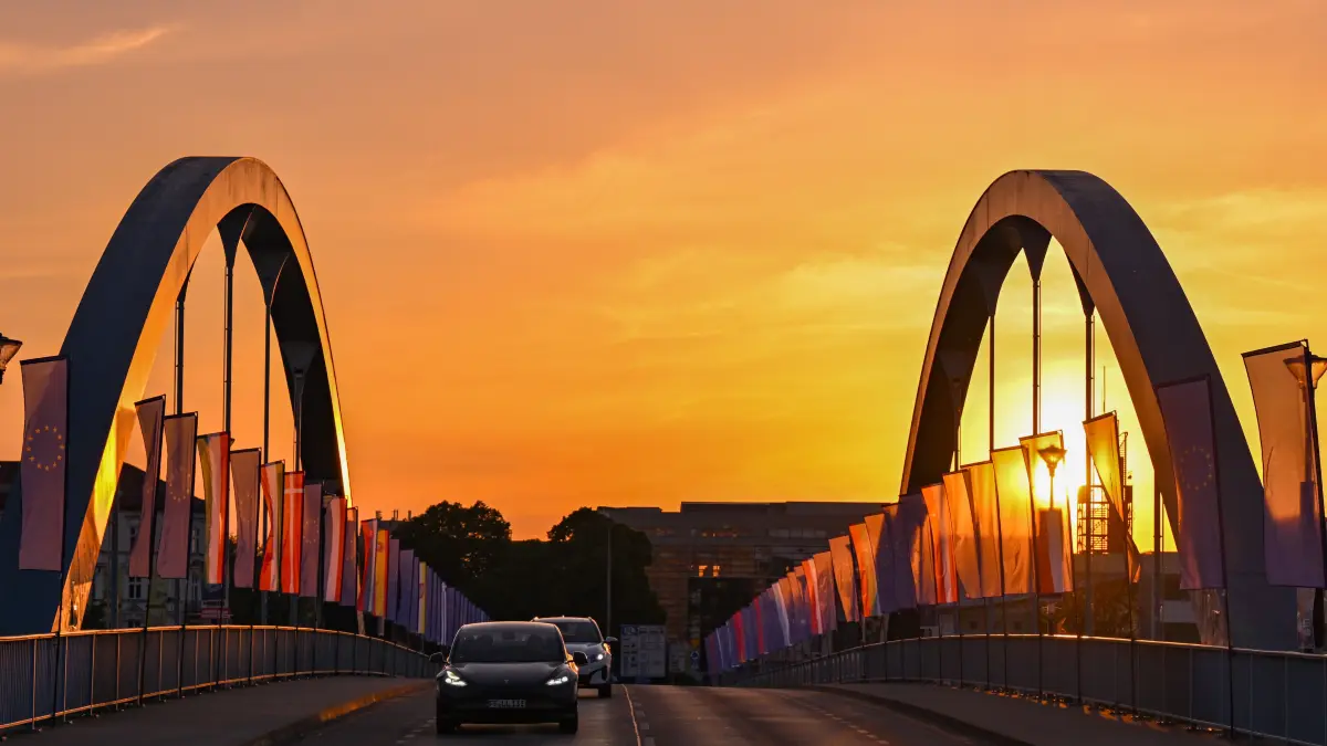 Autos fahren zum Sonnenaufgang über die Stadtbrücke über den Grenzfluss Oder zwischen Frankfurt (Oder) und dem polnischen Slubice.