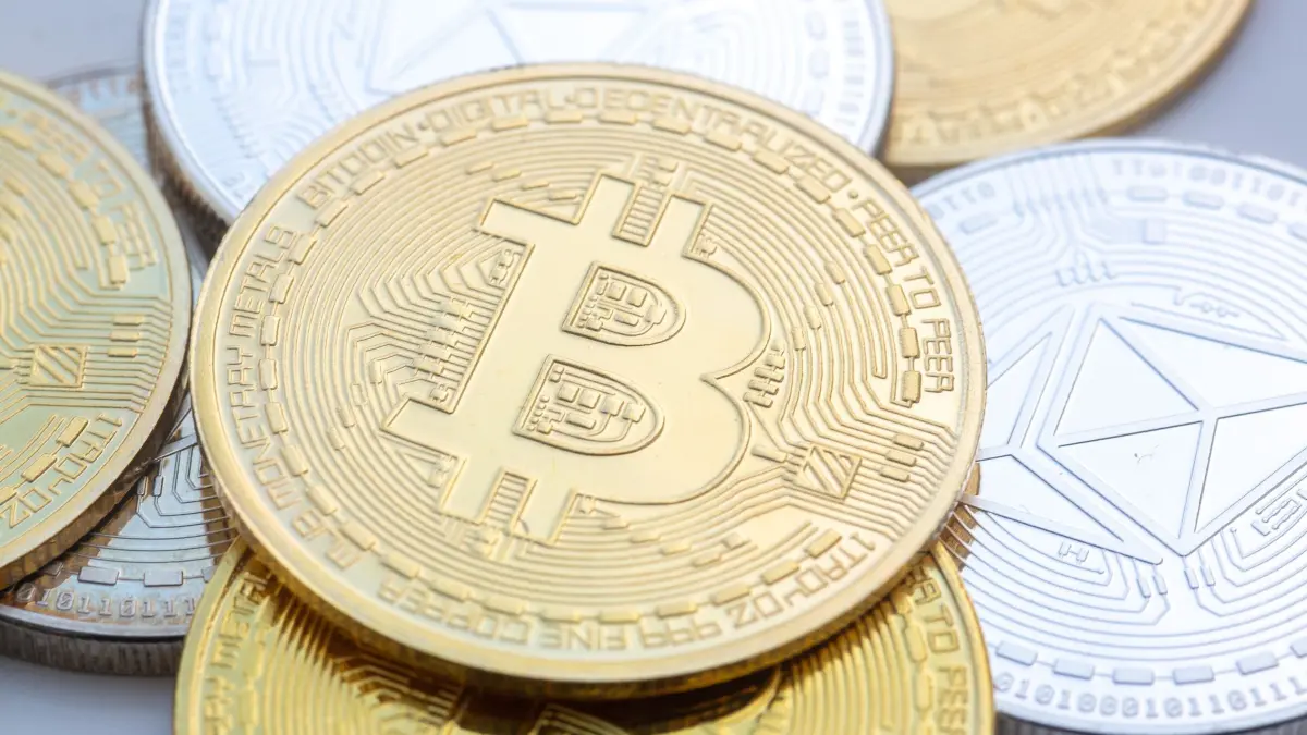 Kryptowährung: ILLUSTRATION - 10.11.2023, Berlin: Münzen mit den Symbolen von Bitcoin (M) und Ethereum sind auf einem Tisch angeordnet. (zu dpa: «Sachsen verfolgt Krypto-Steuersünder mit neuer KI-Software») Foto: Fernando Gutierrez-Juarez/dpa +++ dpa-Bildfunk +++