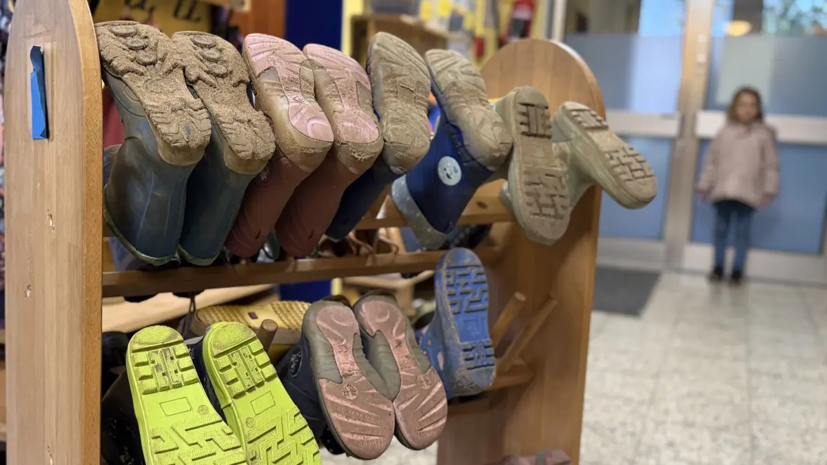 Auf einem Schuhregal haben Kita-Kinder ihre Gummistiefel aufgehängt. Aufgrund sinkender Kinderzahlen kämpfen die ersten Einrichtungen jedoch ums Überleben.