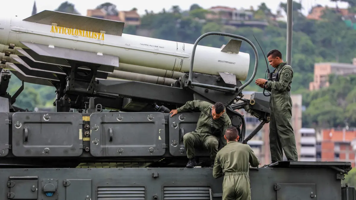 This handout picture released by the Bolivarian National Armed Forces of Venezuela (FANB) on November 12, 2025, shows Venezuelan soldiers inspecting a Russian-made Buk M2E missile system loaded with a missile that reads "Anti-colonialist" during a training exercise in Caracas on November 11, 2025. Venezuela announced on November 11, 2025, what it called a major, nationwide military deployment to counter the US naval presence off its coast. Washington is carrying out a military campaign in the Caribbean and eastern Pacific, deploying naval and air forces it says are aimed at curbing drug trafficking. But the operation has sparked fears in Caracas that the ouster of Venezuelan President Nicolas Maduro is the ultimate US goal. (Photo by Handout / Bolivarian National Armed Forces of Venezuela (FANB) / AFP) / RESTRICTED TO EDITORIAL USE - MANDATORY CREDIT "AFP PHOTO / BOLIVARIAN NATIONAL ARMED FORCES OF VENEZUELA (FANB)" - HANDOUT - NO MARKETING NO ADVERTISING CAMPAIGNS - DISTRIBUTED AS A SERVICE TO CLIENTS - AFP CANNOT INDEPENDENTLY VERIFY THE AUTHENTICITY OR LOCATION, DATE, AND CONTENT OF THESE IMAGES. /
