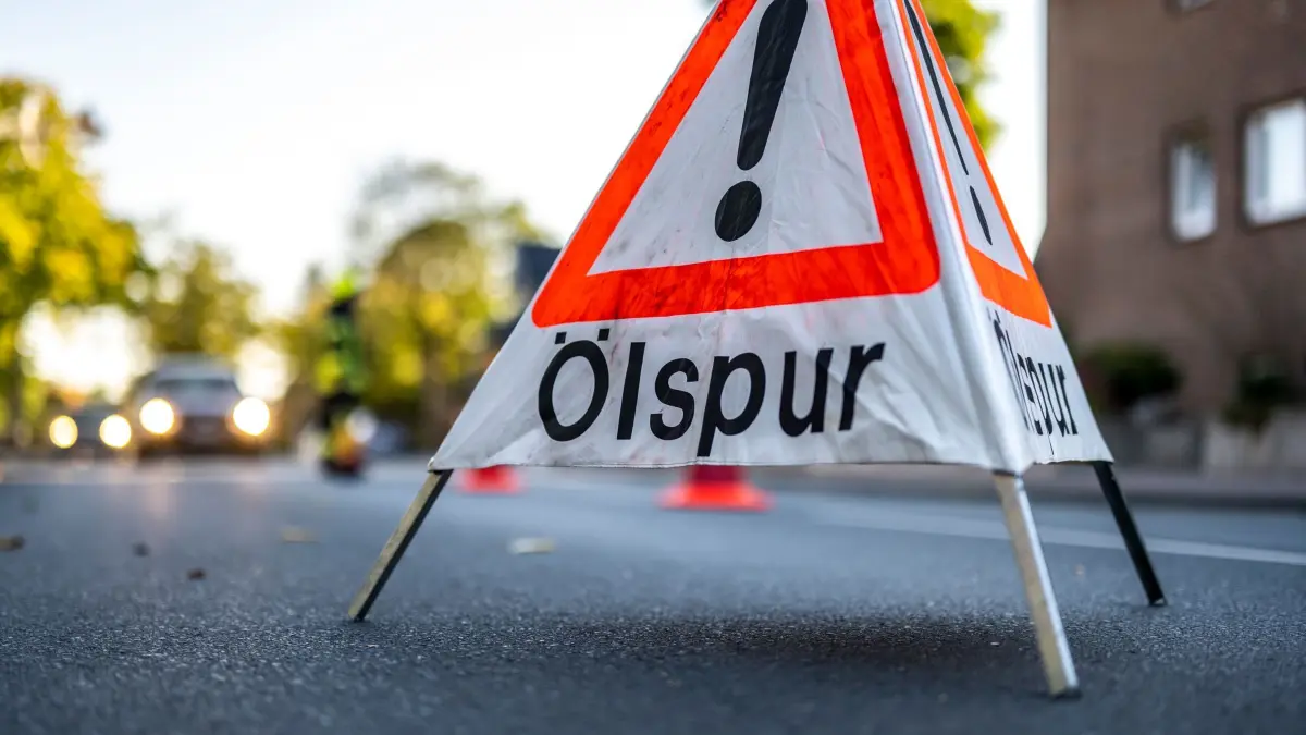 Straßenunfälle setzen Tausende Liter Öl und Gülle frei: PRODUKTION - 09.10.2021, Nordrhein-Westfalen, Wadersloh: Die Feuerwehr hat ein Warnschild mit der Aufschrift «Ölspur» auf die Fahrbahn gestellt. (Symbolbild) (zu dpa: «Gülle, Öl, Kraftstoff: 51 «Umwelt-Unfälle» in Thüringen») Foto: David Inderlied/dpa +++ dpa-Bildfunk +++