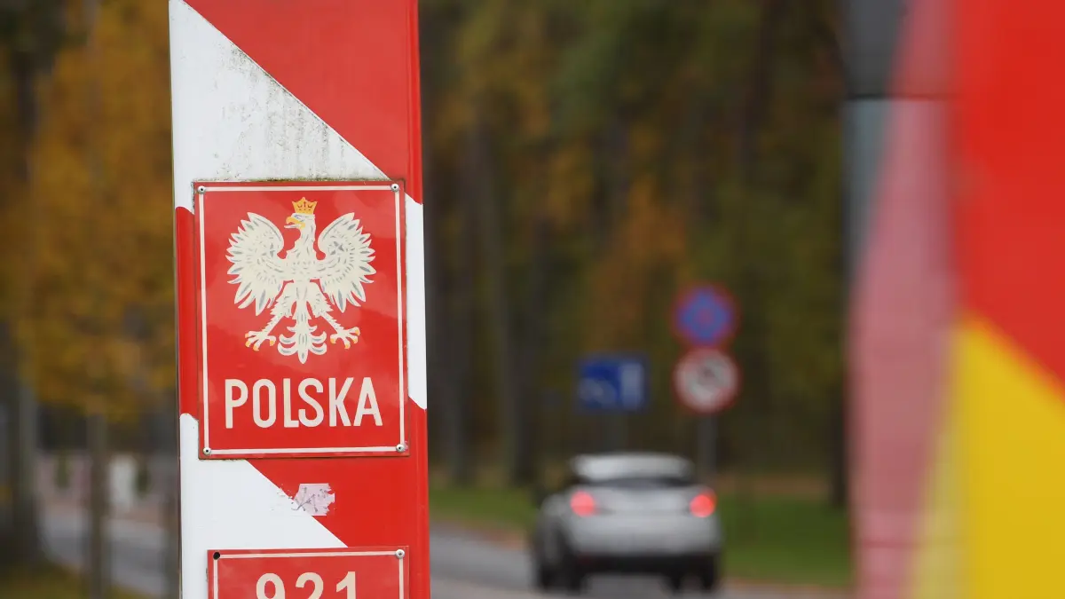 Autos fahren an den Grenzpfählen von Deutschland und Polen vorbei über den Grenzübergang auf der Insel Usedom.