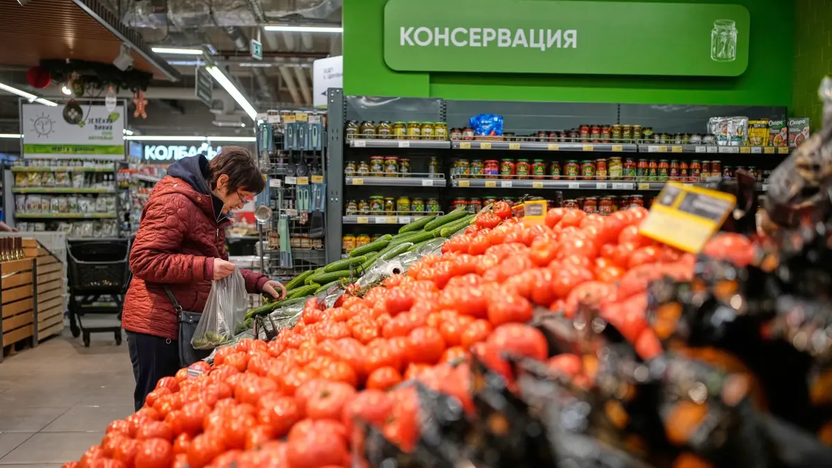 Russland - Wirtschaft: 20.11.2025, Russland, Moskau: Eine Frau packt sich Gemüse in einem Supermarkt zusammen. Foto: Pavel Bednyakov/AP/dpa +++ dpa-Bildfunk +++