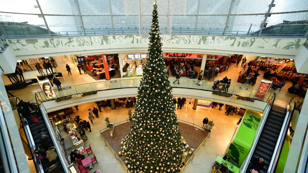 Verkaufsoffener Sonntag am 1. Advent. Ein großer geschmückter Weihnachtsbaum steht in einem Einkaufszentrum.