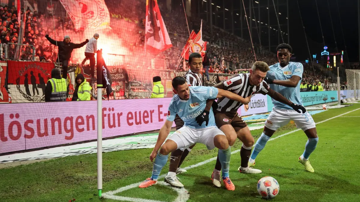 FC St. Pauli - 1. FC Union Berlin: 23.11.2025, Hamburg: Fußball: Bundesliga, FC St. Pauli - 1. FC Union Berlin, 11. Spieltag, Millerntor-Stadion, Rani Khedira (1. FC Union Berlin, l) und Derrick Köhn (1. FC Union Berlin,r) im Kampf um den Ball an der Eckfahne mit Hauke Wahl (FC St. Pauli) und Joel Chima Fujita (FC St. Pauli, 2.v.l). Foto: Christian Charisius/dpa - WICHTIGER HINWEIS: Gemäß den Vorgaben der DFL Deutsche Fußball Liga bzw. des DFB Deutscher Fußball-Bund ist es untersagt, in dem Stadion und/oder vom Spiel angefertigte Fotoaufnahmen in Form von Sequenzbildern und/oder videoähnlichen Fotostrecken zu verwerten bzw. verwerten zu lassen. +++ dpa-Bildfunk +++