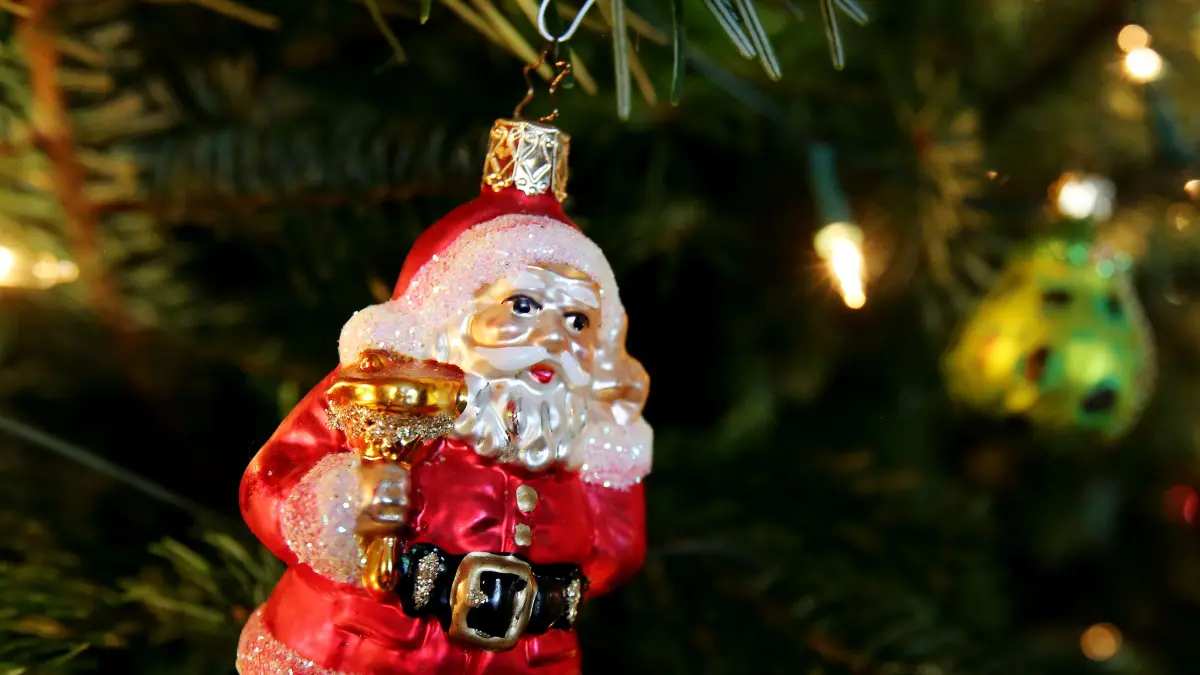 ARCHIV - Eine Weihnachtsbaumkugel in Form eines Weihnachtsmanns hängt am 24.12.2014 an einem Weihnachtsbaum. Sachsen-Anhalts Unternehmen sorgen für Weihnachtsstimmung. Foto: Malte Christians/dpa (zu «Firmen sorgen für Weihnachtsstimmung - Bäume und Feste» vom 21.11.2015) +++ dpa-Bildfunk +++