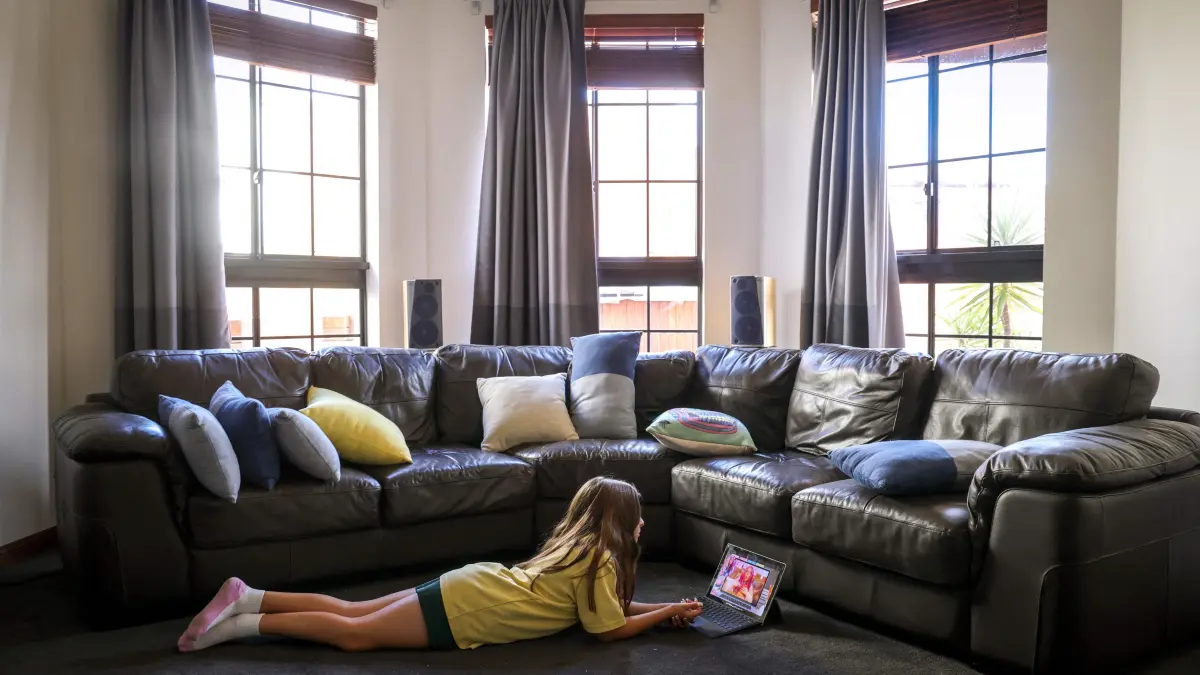 (FILES) This photo taken on October 30, 2025 shows 10-year-old Bianca Navarro lying on the floor as she watches a show on YouTube at her home in western Sydney. Australia's under-16 social media ban will make the nation a real-life laboratory on how best to tackle the technology's impact on young people, experts say. Those in favour of the world-first December 10 ban point to a growing mass of studies that suggest too much time online takes a toll on teen wellbeing. (Photo by David GRAY / AFP)