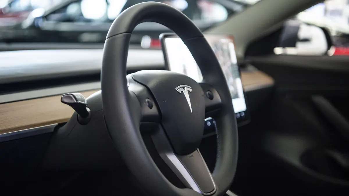 Auf dem Lenkrad des Elektroautos Model 3 von Tesla in einem Ausstellungsraum ist das Logo zu sehen. Am 14.07.2020 verkündet das Landgericht München seine Entscheidung über die Klage der Wettbewerbszentrale gegen Tesla wegen der «Autopilot»-Werbung. +++ dpa-Bildfunk +++
