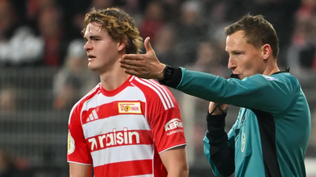 1. FC Union Berlin - FC Bayern München: 03.12.2025, Berlin: Fußball: DFB-Pokal, 1. FC Union Berlin - FC Bayern München, Achtelfinale, An der Alten Försterei, Schiedsrichter Martin Petersen (r) entscheidet nach Ansicht der VAR-Bilder auf Elfmeter für Union. Links neben ihm steht Tom Rothe (1. FC Union Berlin). Foto: Soeren Stache/dpa - WICHTIGER HINWEIS: Gemäß den Vorgaben der DFL Deutsche Fußball Liga bzw. des DFB Deutscher Fußball-Bund ist es untersagt, in dem Stadion und/oder vom Spiel angefertigte Fotoaufnahmen in Form von Sequenzbildern und/oder videoähnlichen Fotostrecken zu verwerten bzw. verwerten zu lassen. +++ dpa-Bildfunk +++
