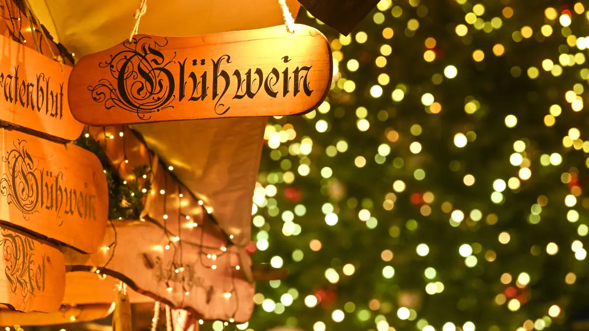 Ein Holzschild mit der Aufschrift "Glühwein" hängt auf einem Weihnachtsmarkt (Symbolbild)