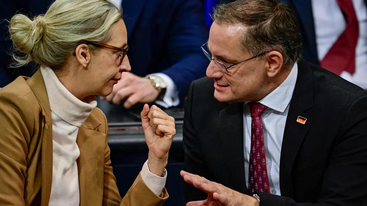 Co-leader of the far-right Alternative for Germany (AfD) party Alice Weidel (L) confer with co-leader of the far-right Alternative for Germany (AfD) party Tino Chrupalla (R) during a sitting of the Bundestag, Germany's lower house of parliament in Berlin on December 5, 2025. German MP's are voting on a controversial pension package and a new military service plan. (Photo by Tobias SCHWARZ / AFP)