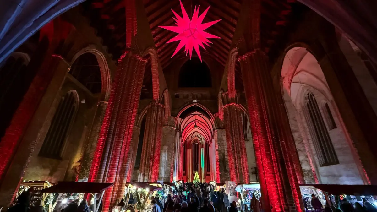 Stimmungsvoller Adventsmarkt in der Marienkirche: 07.12.2025, Brandenburg, Frankfurt (Oder): Festlich beleuchtet ist die Marienkirche zum Adventsmarkt am Abend des 07. Dezember. In der Marienkirche in Frankfurt (Oder) hat am Wochenende der traditionelle Adventsmarkt zahlreiche Besucherinnen und Besucher angezogen. Zwischen festlich geschmückten Ständen boten Händler Kunsthandwerk, regionale Spezialitäten und weihnachtliche Leckereien an. Auch musikalische Darbietungen und ein Kinderprogramm sorgten für stimmungsvolle Unterhaltung. Der Markt gilt als einer der Höhepunkte im vorweihnachtlichen Veranstaltungskalender der Stadt. Veranstalter und Aussteller zeigten sich zufrieden mit der Resonanz. Der Adventsmarkt in der Marienkirche öffnet auch am kommenden Wochenende, vom 13. bis 14. Dezember, erneut seine Tore. Foto: Patrick Pleul/dpa/ZB - Honorarfrei nur für Bezieher des Dienstes ZB-Funkregio Ost +++ ZB-FUNKREGIO OST +++