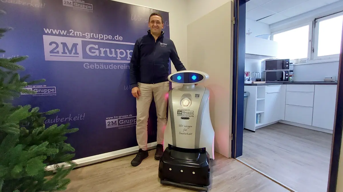 Oliver Majowski, der Gründer und Geschäftsführer der Reinigungsfirma „2M Gruppe GmbH“, neben dem Reinigungsroboter „Franzi“, ein Gerät der Marke „Lionsbot“.