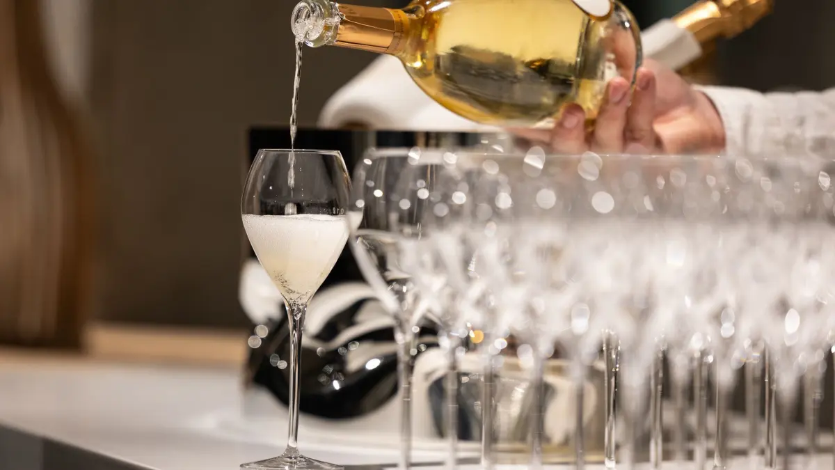 Kellner schenkt ein Glas Champagner ein