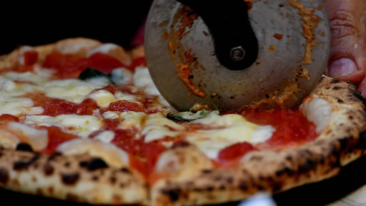 (FILES) A picture shows a pizza cooked at the Capodimonte museum hosting the first stone oven where was cooked a Pizza Margherita, on December 6, 2017 in Naples. Italy is waiting for the final decision of Unesco, today on December 10, 2025, regarding the recognition of Italian cuisine as an "Intangible Cultural Heritage of Humanity". (Photo by TIZIANA FABI / AFP)