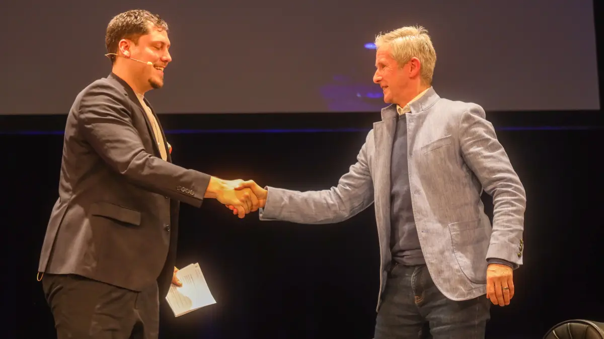 Moderator David Friedrich (l.) begrüßt Skisprung-Legende Jens Weißflog beim MOZ-Talk im Kleist Forum Frankfurt (Oder).