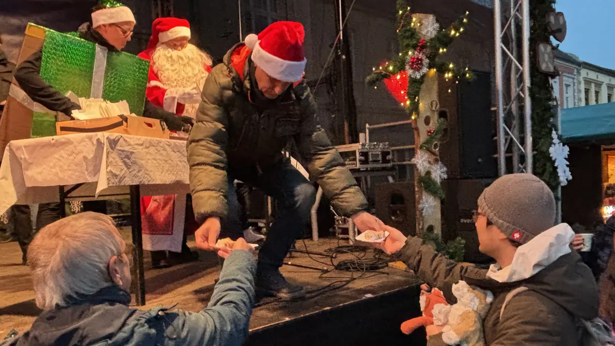 Bürgermeister Frank Balzer hat zur Eröffnung des Weihnachtsmarktes im Eisenhüttenstädter Ortsteil Fürstenberg Christstollen verteilt.