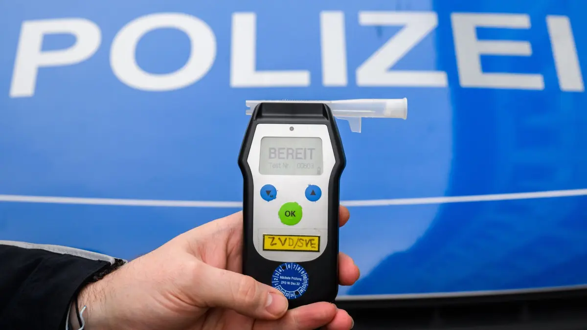 ARCHIV - 28.01.2025, Niedersachsen, Hannover: ILLUSTRATION - Ein Polizist zeigt einen Alkoholtest (Atemtest), mit dem Verkehrsteilnehmer auf ihre Fahrtüchtigkeit hin überprüft werden können (gestellte Szene). (zu dpa: «Betrunkener Teenager legt sich in fremdes Auto schlafen») Foto: Julian Stratenschulte/dpa +++ dpa-Bildfunk +++