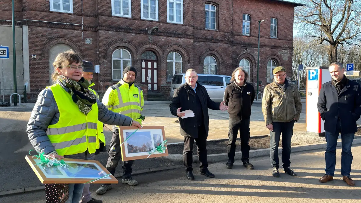 Danksagung an die Bauarbeiter in Letschin: Ute Büttner (l.) vom Bauamt hat den Mitarbeitern der Firma Porr und dem Planungsbüro Altus aus Lebus Fotos vom Letschiner Bahnhofsvorplatz übergeben, der von einem Regenbogen überspannt wird.