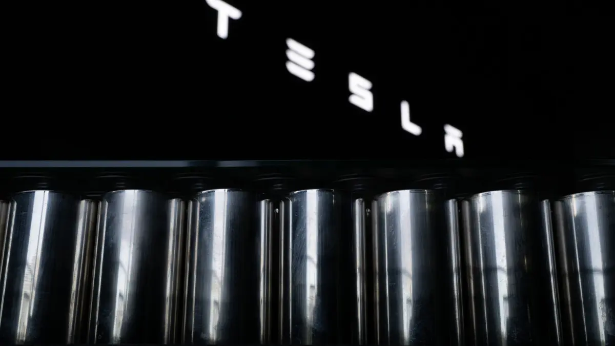 Tesla Gigafactory Berlin-Brandenburg: 16.12.2025, Brandenburg, Grünheide: Der Tesla-Schriftzug ist in der Tesla Gigafactory Berlin-Brandenburg über einem Tisch aus Batteriezellen zu sehen. (zu dpa: «Tesla peilt komplette Batteriefertigung in Deutschland an») Foto: Sebastian Gollnow/dpa +++ dpa-Bildfunk +++