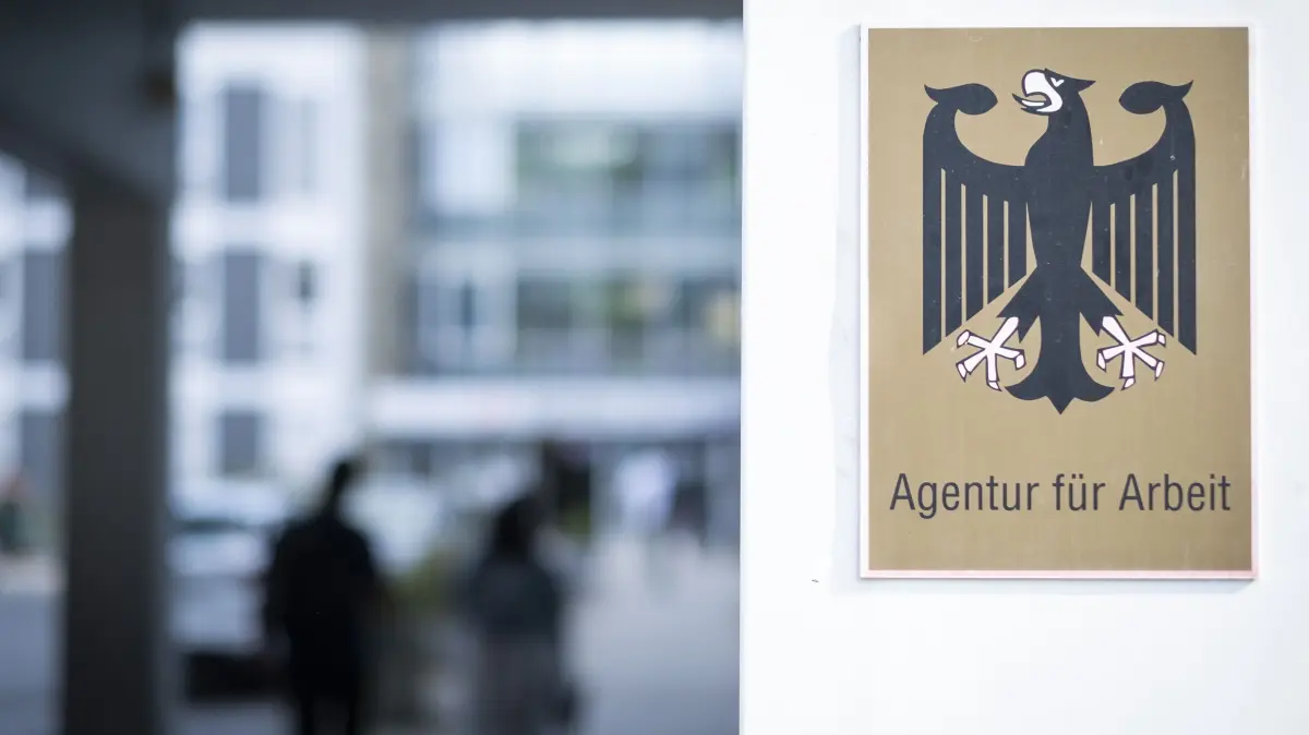 Kabinett beschliesst Umbau des Buergergelds zur Grundsicherung: Schild mit Bundesadler an der Agentur fuer Arbeit in Franfurt am Main (Foto vom 02.08.2024). Nach langwierigen Verhandlungen innerhalb der Koalition hat die Bundesregierung den Umbau des Buergergelds zur neuen Grundsicherung auf den Weg gebracht. Das Bundeskabinett beschloss am 17.12.2025 den Gesetzentwurf des Bundesarbeitsministeriums, der dem Evangelischen Pressedienst (epd) vorliegt. Vorgesehen ist unter anderem die Rueckkehr zum sogenannten Vermittlungsvorrang: Die Vermittlung in Arbeit hat dann in der Regel Vorrang vor einer Ausbildung oder Qualifizierung. (Siehe epd-Meldung vom 17.12.2025)