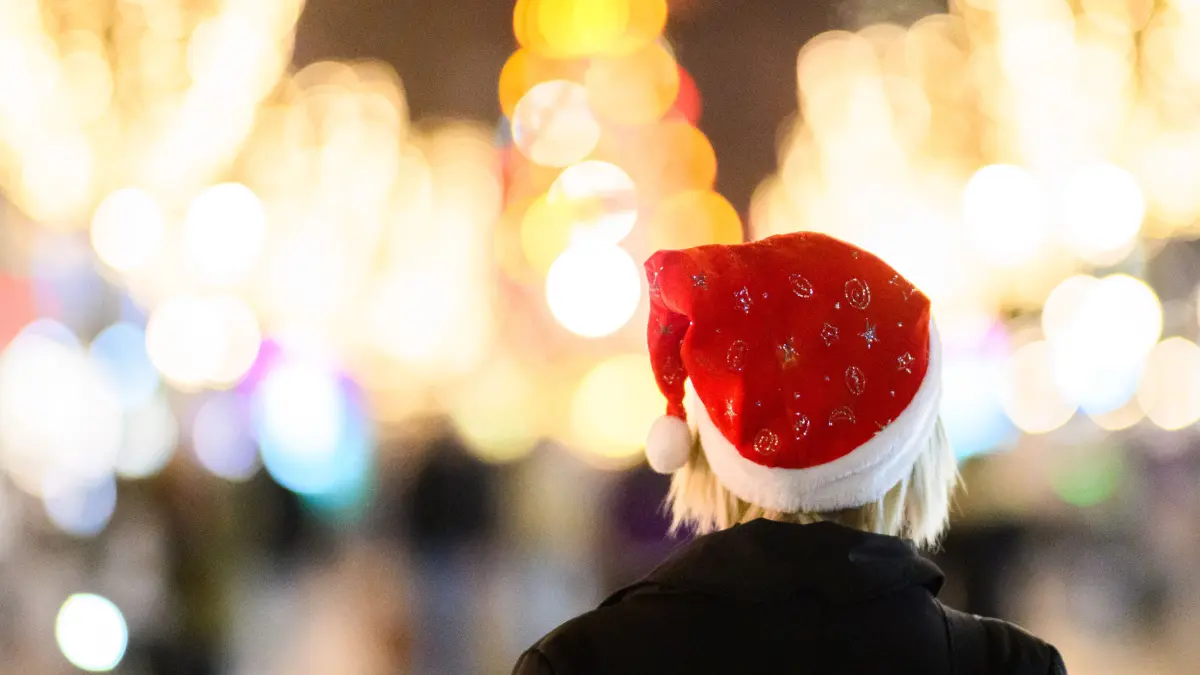 Eine Frau läuft mit einer Nikolausmütze durch die Innenstadt. Die deutschen Weihnachtsmärkte rüsten nach Anschlägen in früheren Jahren massiv auf. +++ dpa-Bildfunk +++