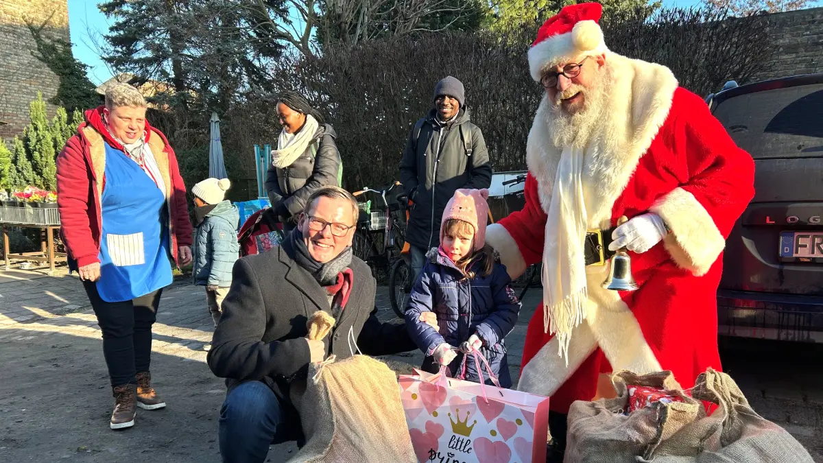 Bescherung in Eberswalde: Der Unternehmer und Kommunalpolitiker Dietmar Ortel (l.) und Weihnachtsmann Henry Pepinksi beschenken auf dem Hof der Suppenküche auch die kleine Matilda (3,5), die sich schon riesig auf die Feiertage freut.