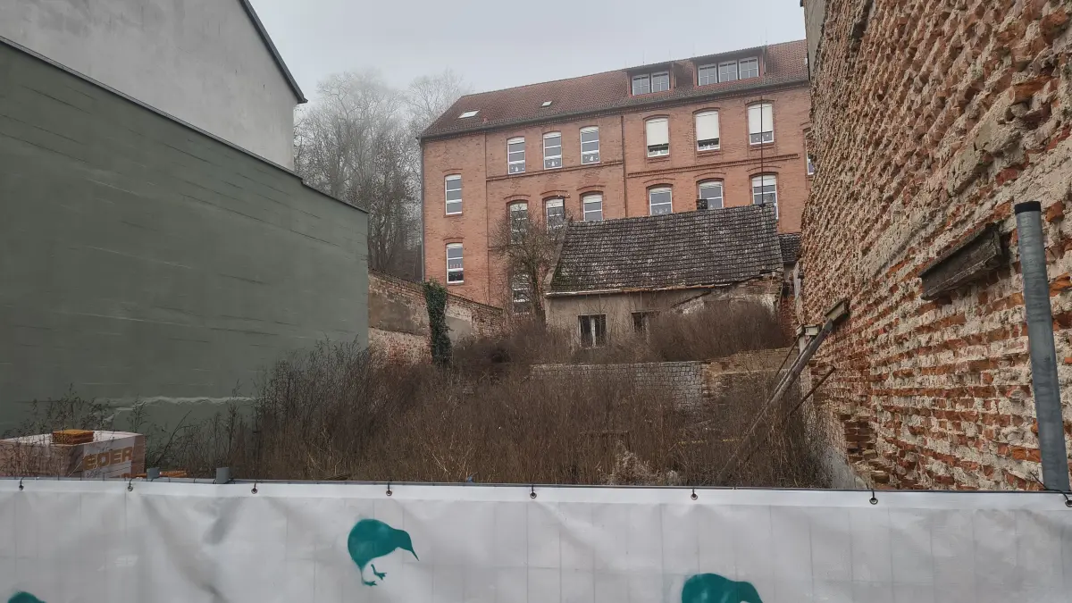 Das Grundstück an der Berliner Straße 83 in Oderberg im Dezember 2025. Im Hintergrund die Grundschule von Oderberg, vor der ein ehemaliges Wohnhaus steht.